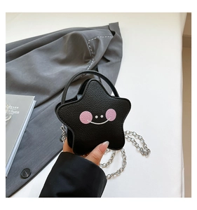 Detailed macro of a black star-shaped mini crossbody bag with a cute smile face design