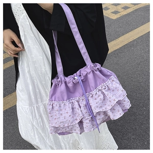 Detalle del bolso tote de lona morada con volantes florales y cierre de cordón