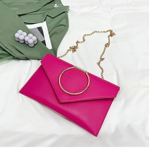 Détail de la pochette enveloppe rose avec poignée anneau doré et bandoulière chaîne