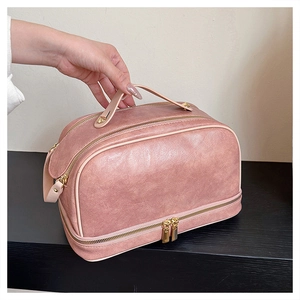 Detail view of pink large capacity makeup bag with double zippers and bottom compartment