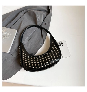 Detailaufnahme einer schwarzen Hobo-Tasche mit dichten silbernen Nietendekorationen