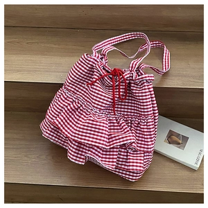 Detail of red gingham tote bag featuring layered ruffles and functional red drawstring