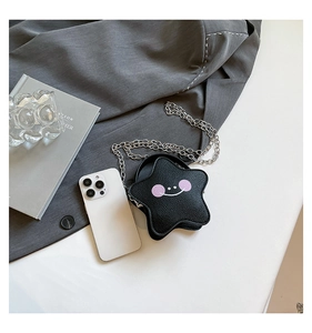 Detail of star-shaped crossbody bag with litchi grain texture and a cartoon smile face