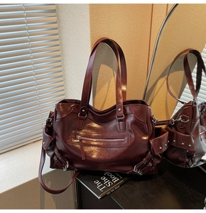 Detail of burgundy tote bag showing vintage oil wax leather texture and silver rivets