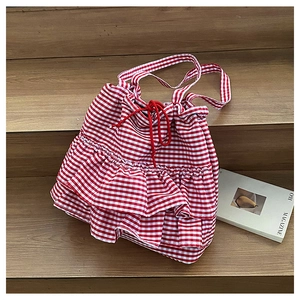 Detailed shot of red and white checkered bucket bag with ruffles on wooden stairs