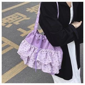 Detalle del bolso tote lila con volantes florales y cierre de cordón ajustable de moda