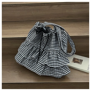 Detail of checkered tote bag featuring tiered ruffle layers and drawstring closure