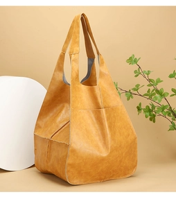 Close-up of soft ginger leather tote bag with fine stitching and side patch pocket detail