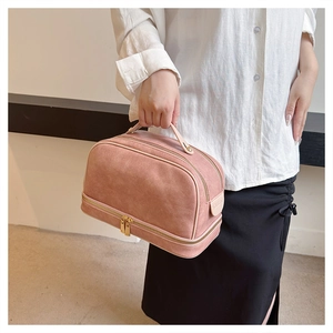 Detail of pink textured faux leather makeup bag with double-layer zipper compartments