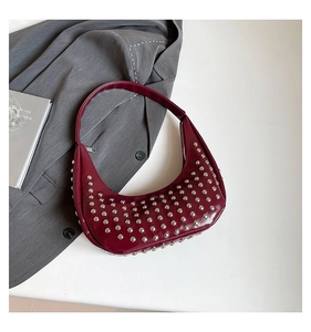 Detailansicht einer dunkelroten Punk-Hobo-Tasche mit Nieten und glänzender Lederoptik