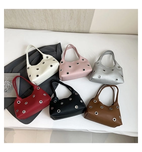 Flat lay of hollowed rivet underarm bags in six colors with metallic eyelet accents