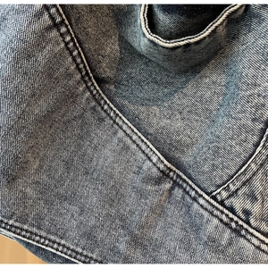 Detailed close-up of vintage blue denim fabric showing textured wash and stitching
