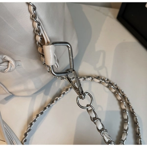 Detail of silver chain strap and metal clasp on beige waterproof shoulder bag