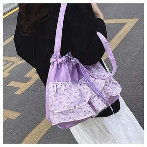 Detalle de los volantes florales morado claro en un bolso tote de gasa suave