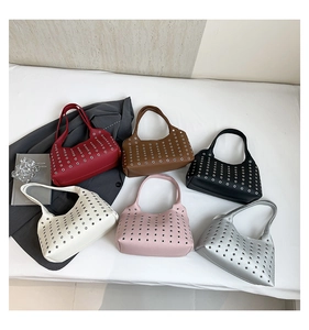Close-up of trendy hollow-out rivet underarm bags in various colors and leather texture