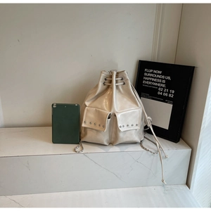 Detail of creamy white leather bucket bag with silver studs and chain straps