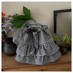 Detail of black and white gingham tote bag with triple-layered ruffles and drawstring