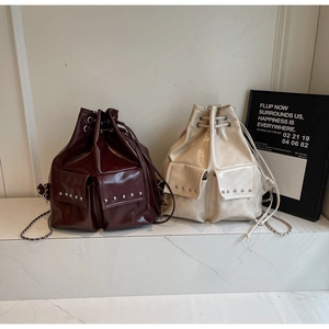 Detail of studded bucket backpack with metallic chain strap and drawstring closure