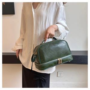 Macro detail of dark green vintage leather toiletry bag with double gold zippers