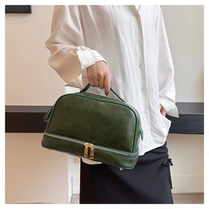 Detailed macro view of the dark green vintage handbag featuring gold metal zippers