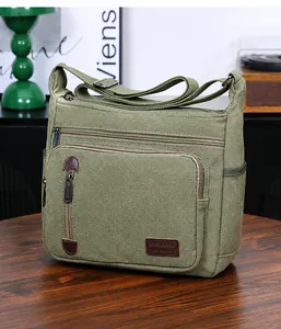 Detailansicht der militärgrünen Canvas-Schultertasche mit Taschen und Bronze-Beschlägen