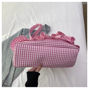 Detail view of the pink gingham tote bag featuring delicate ruffle edges and canvas texture