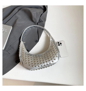 Detailansicht der silbernen halbmondförmigen Tasche mit modischen Punk-Nieten