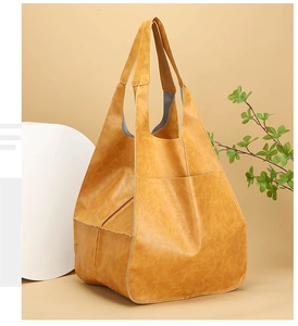 Detail of vintage ginger yellow tote bag with large capacity and soft faux leather texture