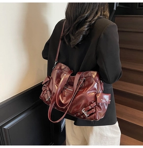 Close-up of wine red faux leather motorcycle tote bag with rivet details and hardware