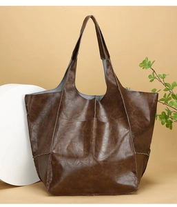 Close-up of vintage brown leather tote bag with pleated texture and fine stitching detail