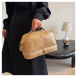 Detail view of khaki faux leather cosmetic bag with double layers and sturdy top handle