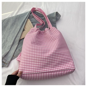 Pink and white gingham tote bag displayed on white fabric with a denim jacket