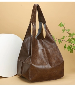 Close-up of deep brown vintage faux leather tote bag with glossy oil-wax finish