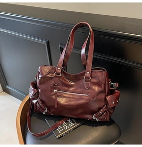 Detailed macro view of the dark red leather tote bag with metallic rivet side pocket