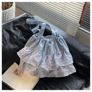 Detalle de bolso tote de lona azul claro con volantes florales de tres capas y cordón