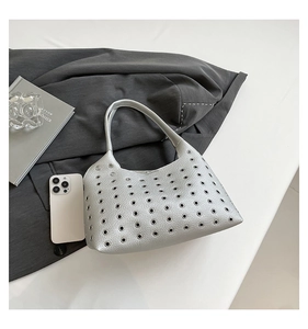 Detail view of silver rivet-decorated underarm bag with lychee texture and metal eyelets