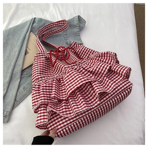 Detail of red gingham tote bag featuring layered ruffles and a red drawstring closure