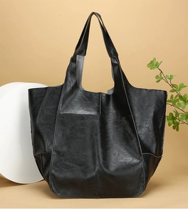 Close-up of black retro oversized tote bag showing soft faux leather texture and stitching