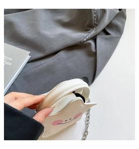 Detail of white pebble grain mini bag with metal chain strap and smiling face
