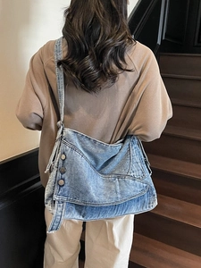 Retro washed blue denim tote bag with metallic buttons and wide strap for casual wear