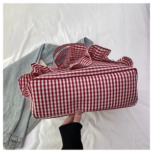 Detail view of the wide bottom base on this large red and white gingham canvas tote bag