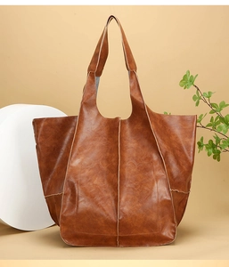 Close-up detail of vintage brown leather tote bag with retro textured stitching and soft finish