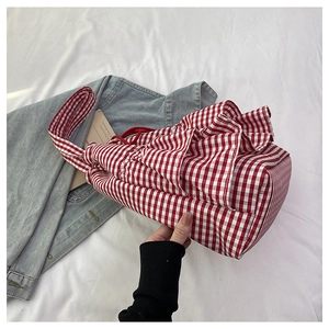 Detail of red and white checkered tote bag with ruffle trim and drawstring closure