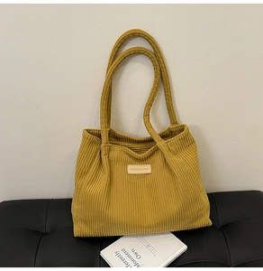 Detailed texture of ginger yellow corduroy tote bag with fashion leather patch