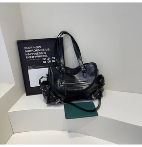 Detailed view of black motorcycle tote bag featuring metal rivets and vintage leather texture
