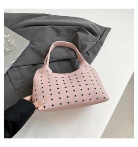 Detail view of pink underarm bag featuring rivet hollow out design and metal eyelets