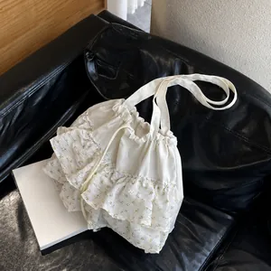 Primer plano de los volantes de gasa floral y cordón ajustable del bolso de lona