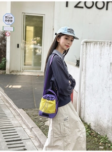 Streetstyle-Ansicht der lila-gelben Flaschentasche mit Kordelzug aus robustem Nylon
