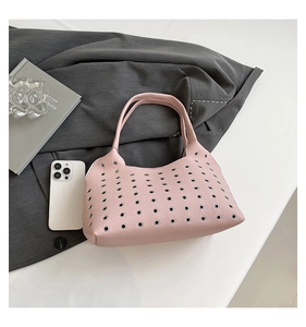 Top view showing pink lychee leather handbag with silver eyelet studs and modern aesthetic