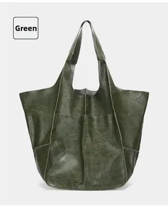 Close-up of dark green vintage tote bag showing wrinkled leather texture and stitching detail